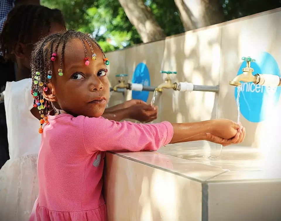 A girl in Haiti washes her hands at a new facility installed at her school.