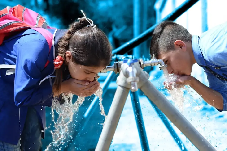 School children in Syria drink safe clean water from a UNICEF-supported water source.