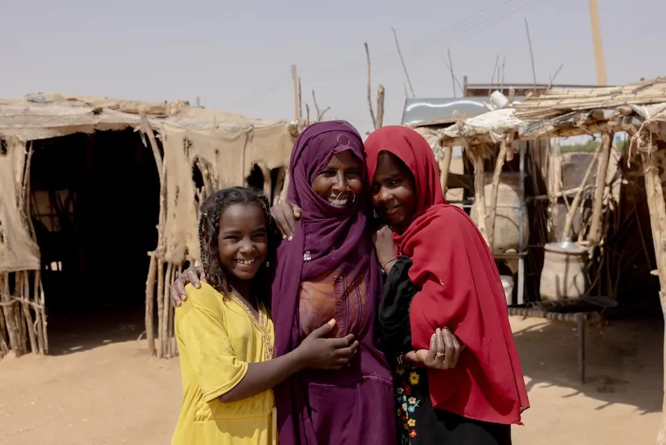 A mother and her daughters outside their home in in Aldamer, River Nile State, Sudan.