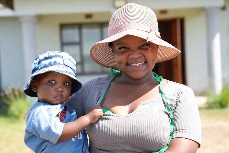Lethokuhle Ngema and her son Kusaselihle Ngema stand outside their home in KwaZulu-Natal, South Africa. 