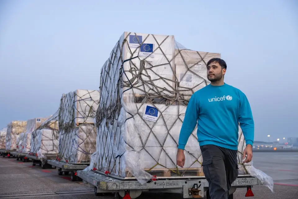 On March 10, 2026, a man in a UNICEF shirt stands in front of a line of pallets containing supplies sent from Copenhagen to Beirut, Lebanon.