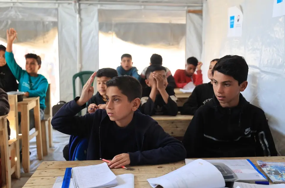 Children sit at desks in a UNICEF temporary learning space in Gaza on March 11, 2026.