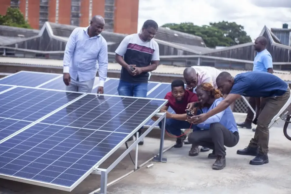 Trainees at a technical school in Zambia examine solar panels which help maintain cold chain storage for vaccines. 