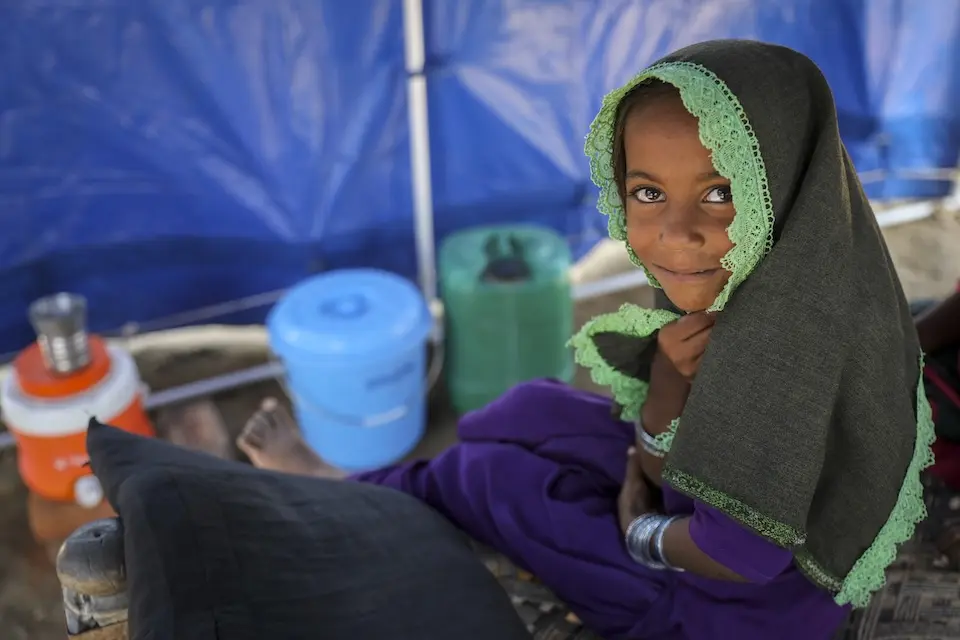 A young girl displaced by flooding in Pakistan shelters in a tent.