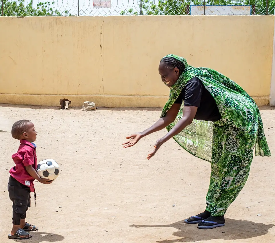 A child plays with a facilitator at the UNICEF-supported Jembia women and girls’ center in Kassala state, Sudan.