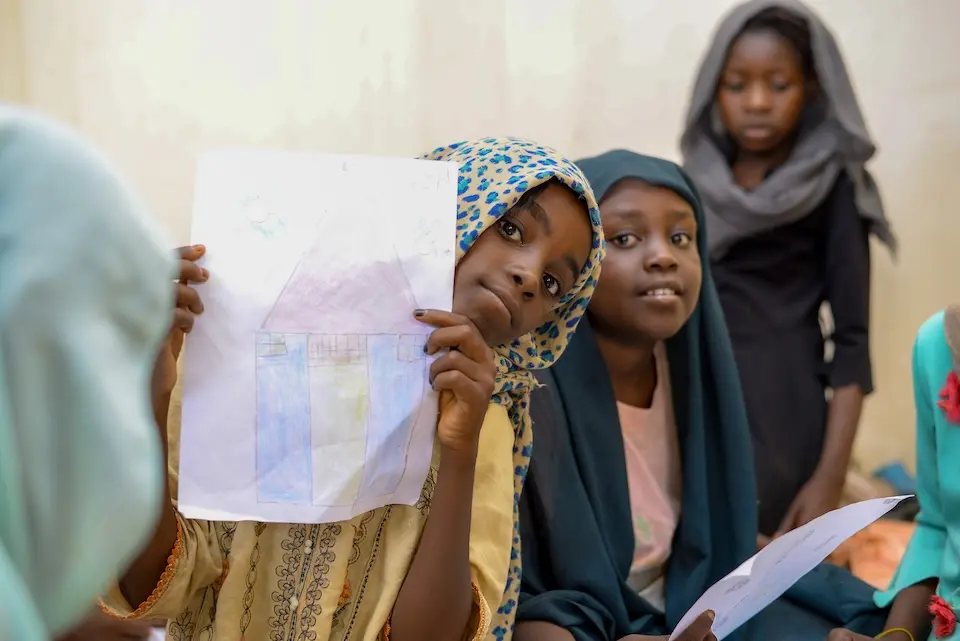 Girls show their art work at the UNICEF-supported Jembia women and girls’ center in Kassala state, Sudan.