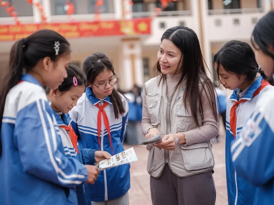 Hoang Lan Anh, a UNICEF officer, introduces a leaflet on mental health to students in Lang Son Province, Vietnam, after storms and floods affected the area. 