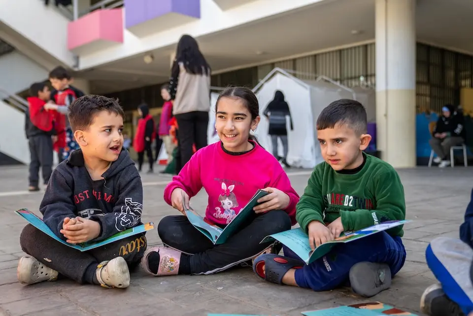 Children read books at a UNICEF-supported displacement shelter in Beirut, Lebanon.