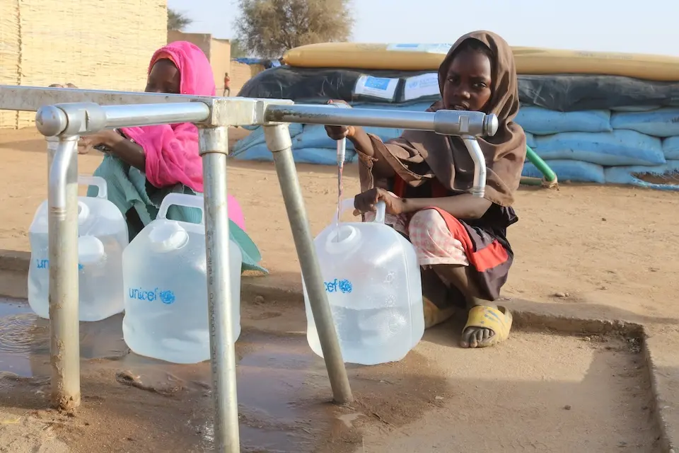 Children displaced by conflict in Al Fasher, Sudan, collect water from a water point installed by UNICEF in a displacement camp in Tawila.