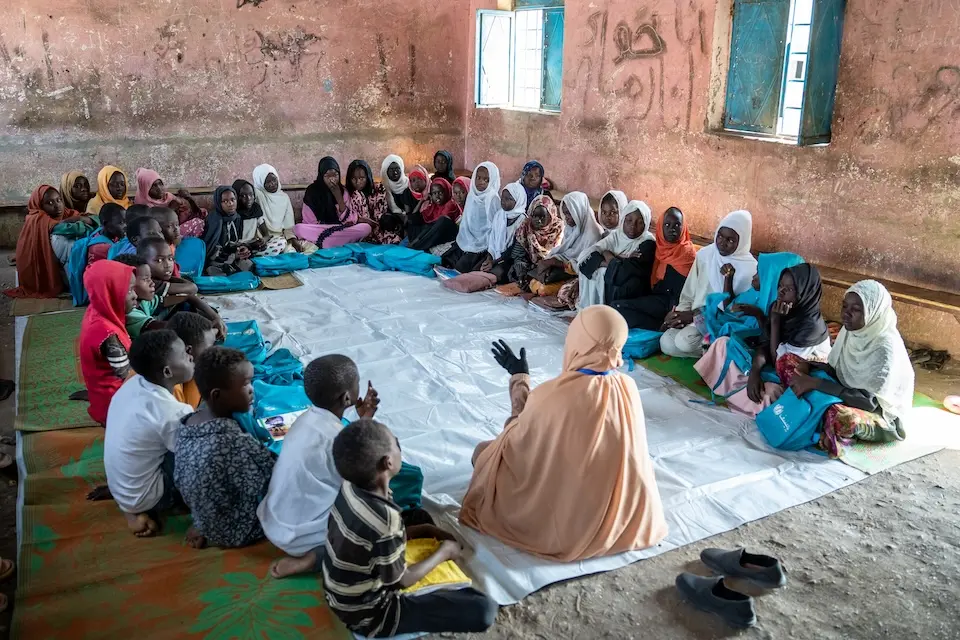 A UNICEF-supported social worker leads a group psychosocial support session at a safe space for children displaced by conflict in Sudan.