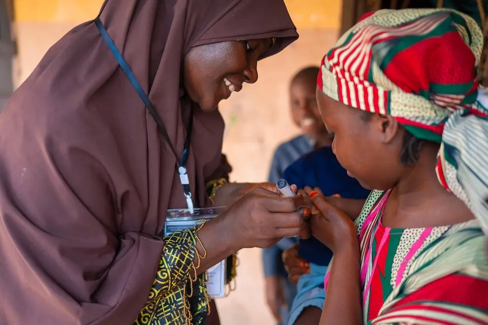 Hauwa Ishiyaku, a vaccinator in Nigeria vaccinates a child against polio during a UNICEF-supported immunization campaign. 