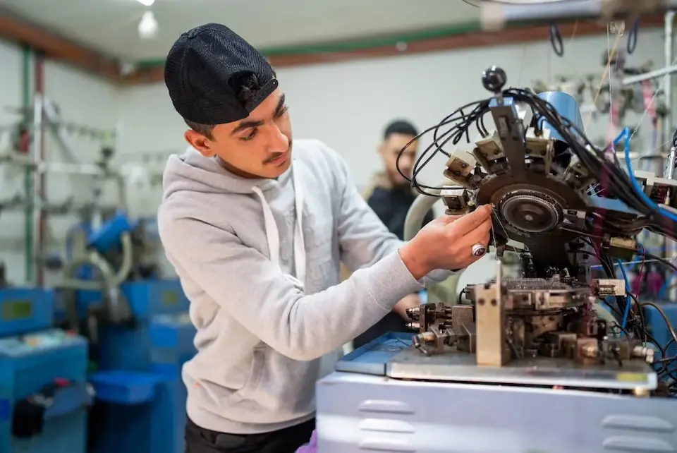 A youth adjusts a sewing machine in Lebanon. 