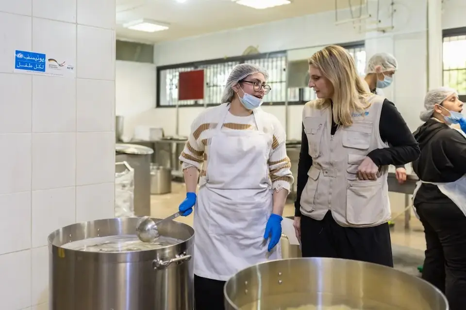 A  youth volunteer speaks with a UNICEF staff person in the kitchen of a shelter for families displaced by war in Lebanon.