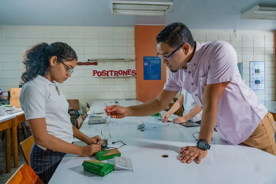 A teacher guides a student in a classroom in Honduras.