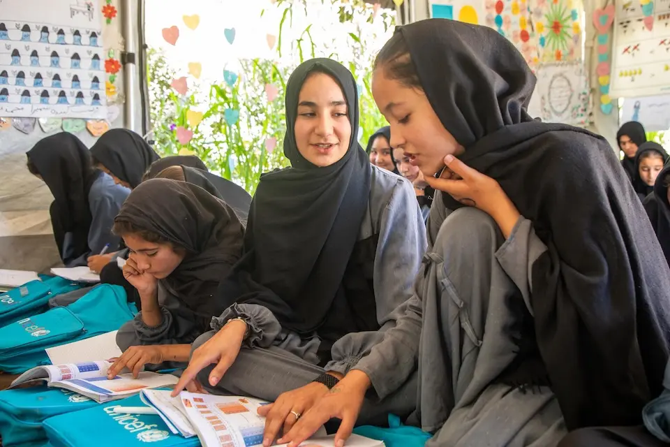 Classmates interact over lessons at a UNICEF-supported accelerated learning center (ALC) in western Afghanistan.