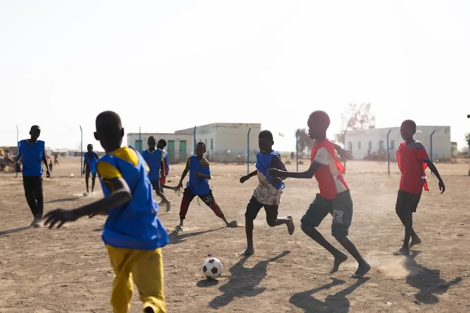 Kids play soccer at a UNICEF-supported child-friendly space at a displacement camp in White Nile State, Sudan.