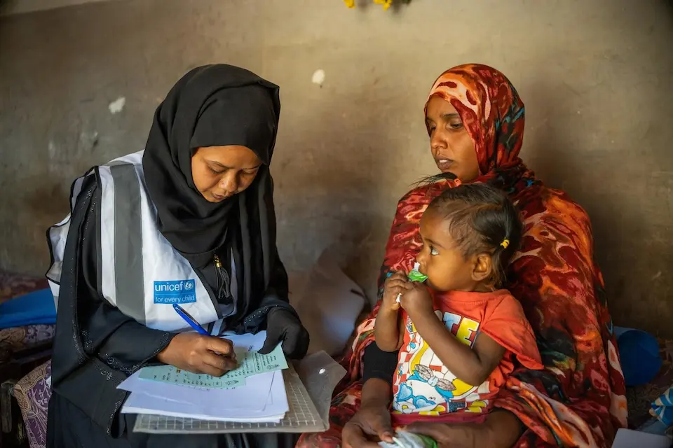 A UNICEF volunteer meets with a mom and her baby to talk about hygiene and health education in Rufaa locality, Al Jazirah State, Sudan. 