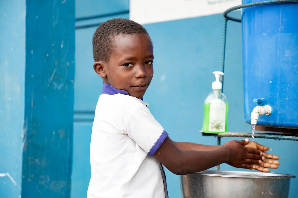 A boy washes his hands outside a UNICEF-supported school in Ituri, DR Congo.