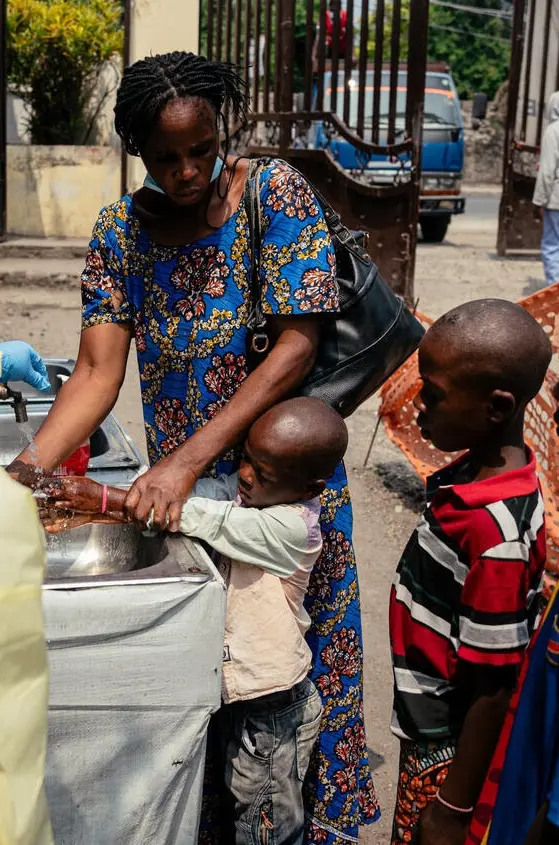 A mother washes her child's hands outside a hospital in Goma, DR Congo.