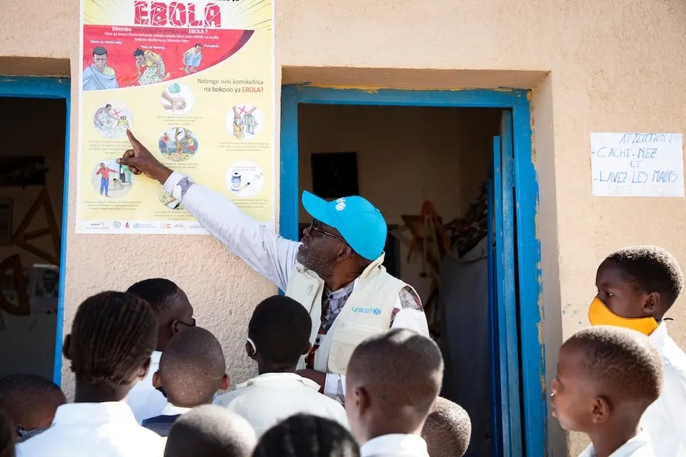 Ebola prevention expert shares information with students outside a school in Ituri province, DR Congo.