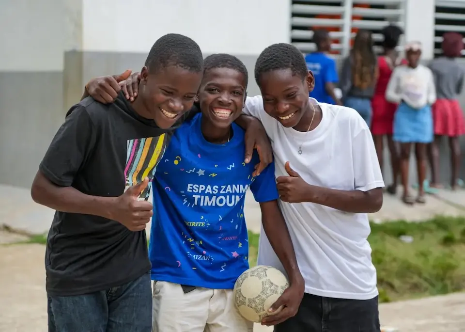 Friends smile together after a soccer match in Haiti in 2026.