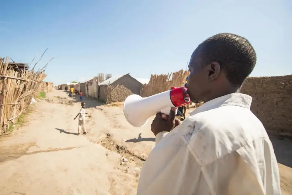 A man holds a bullhorn in rural Gedaref, Sudan.