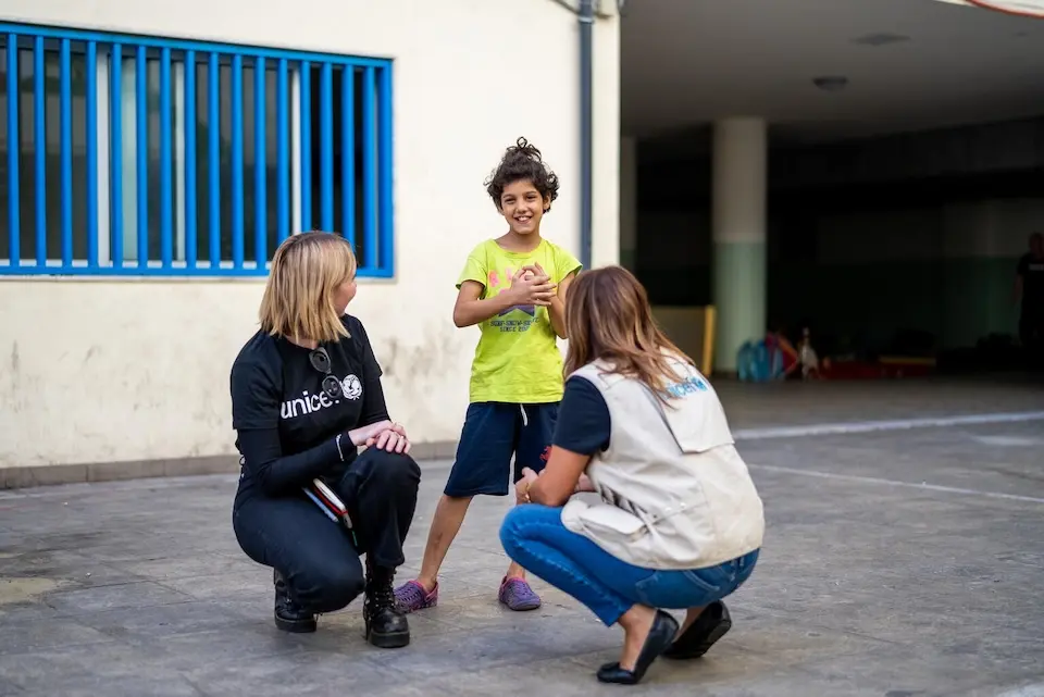 A 9-year-old girl with two UNICEF staff members at a shelter for families displaced by escalating conflict in Lebanon.