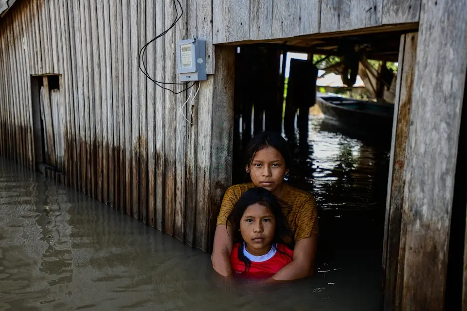 Two children standing in floodwaters in Ucayali, Peru.