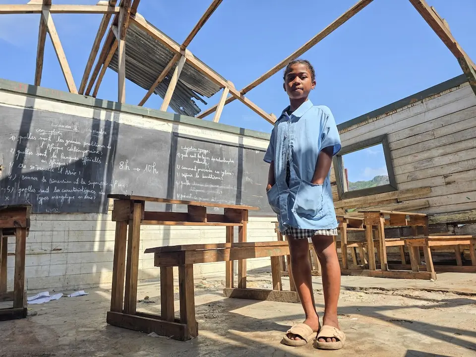 Christianah, 11, standing in her Madagascar classroom destroyed by the tropical storm Jude.