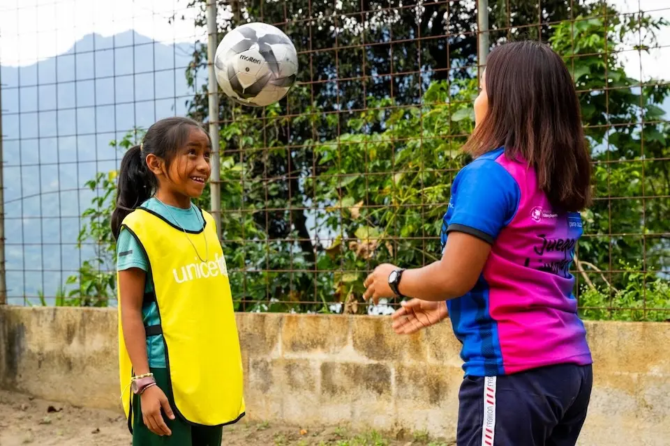 A girl works with a soccer coach in Guatemala. 