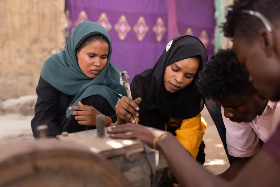 A group of young women repair a faulty generator in Sudan. They are graduates of a UNICEF-supported hands-on vocational training.