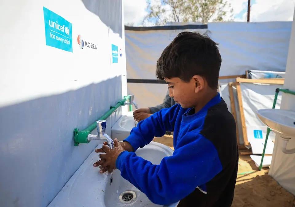 A boy washes his hands at a sink in a UNICEF temporary learning space in the Gaza Strip.