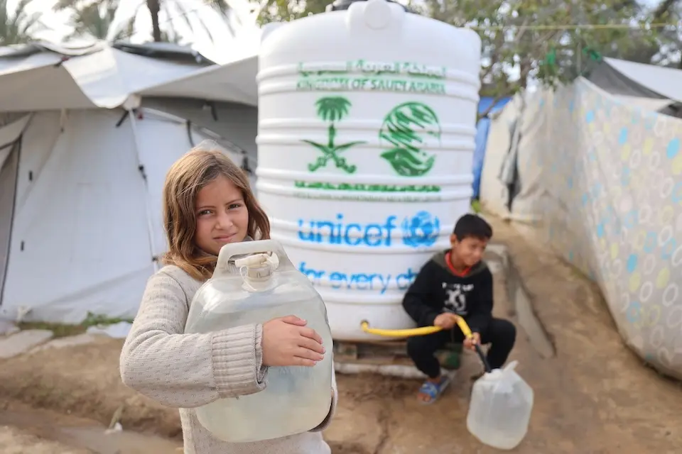 Displaced girl in Gaza City carries a jug of safe water provided by UNICEF.