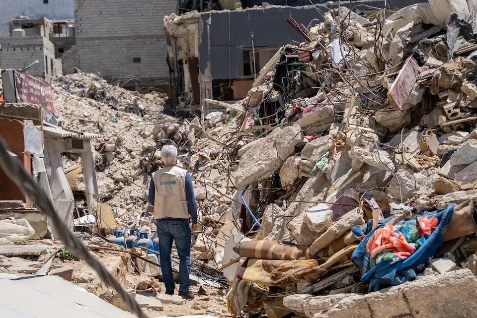 A UNICEF staff member surveys the damage after a bombing attack in Tyre, South Lebanon.