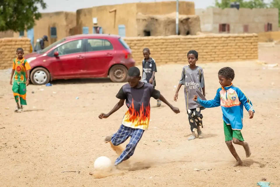 Children play football after school in Mali in 2026.
