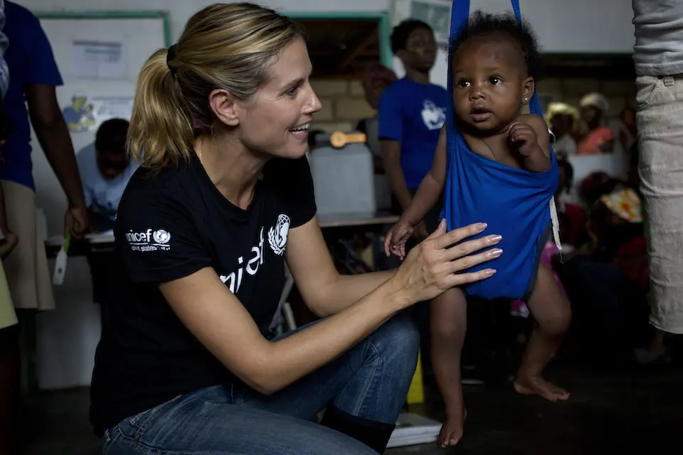 Heidi Klum with a child receiving UNICEF-supported health services in Haiti in 2012.