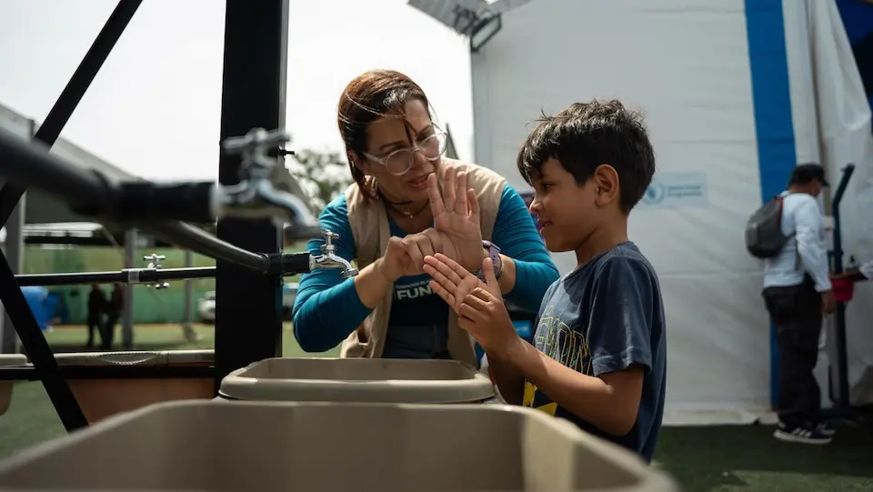 UNICEF staff teach children proper handwashing techniques using a UNICEF portable water station in Venezuela. © UNICEF/UN0889150/Paz 