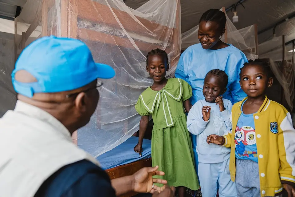 Three children with a caregiver at a nursery UNICEF helped establish at an Ebola treatment center in Bunia, Ituri, DR Congo.