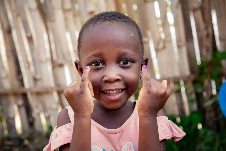 Four-year-old girl in DR Congo shows her marked fingers indicating she has received the polio vaccine.