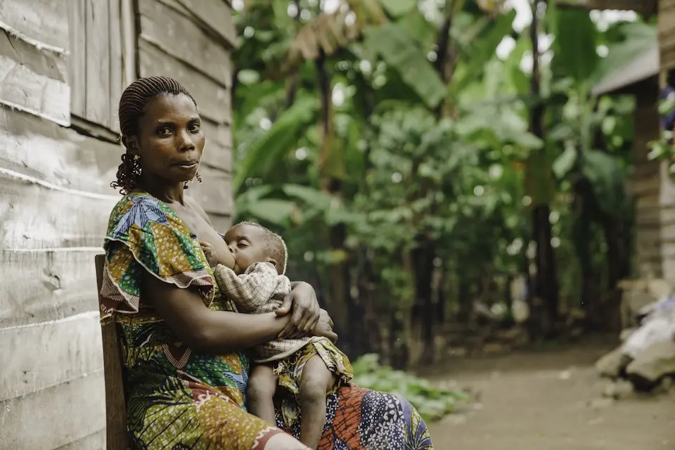 A mother breastfeeds her infant outside their home in Shasha, North Kivu province, DR Congo.