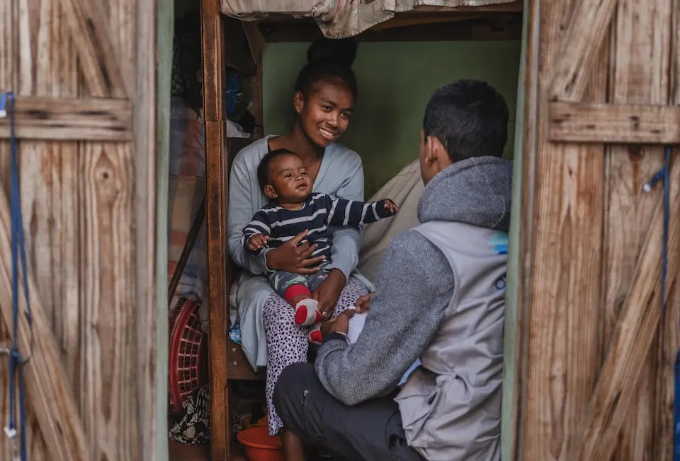 In Madagascar, a mother and young child talk about vaccination with a UNICEF staff person.