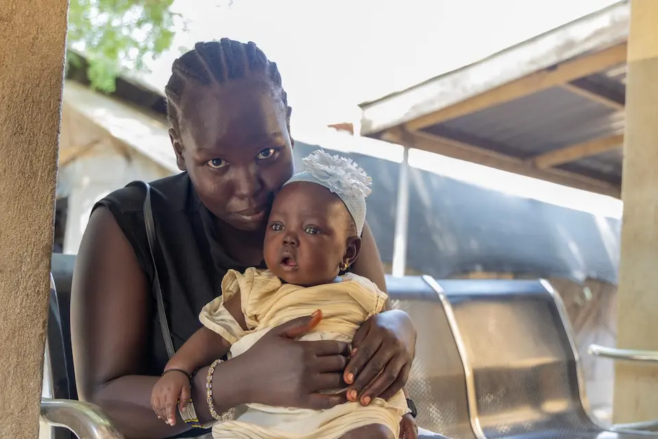 A mother waits for her daughter to be vaccinated at a UNICEF-supported health center in Juba, Central Equatoria State, South Sudan.