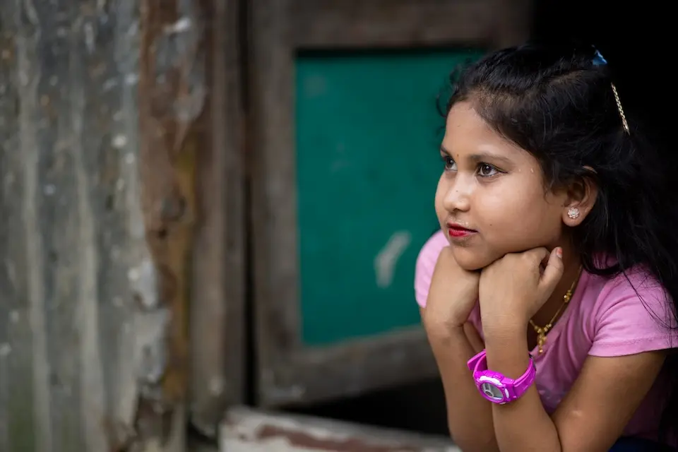 A girl looks out of a window in Bangladesh. 
