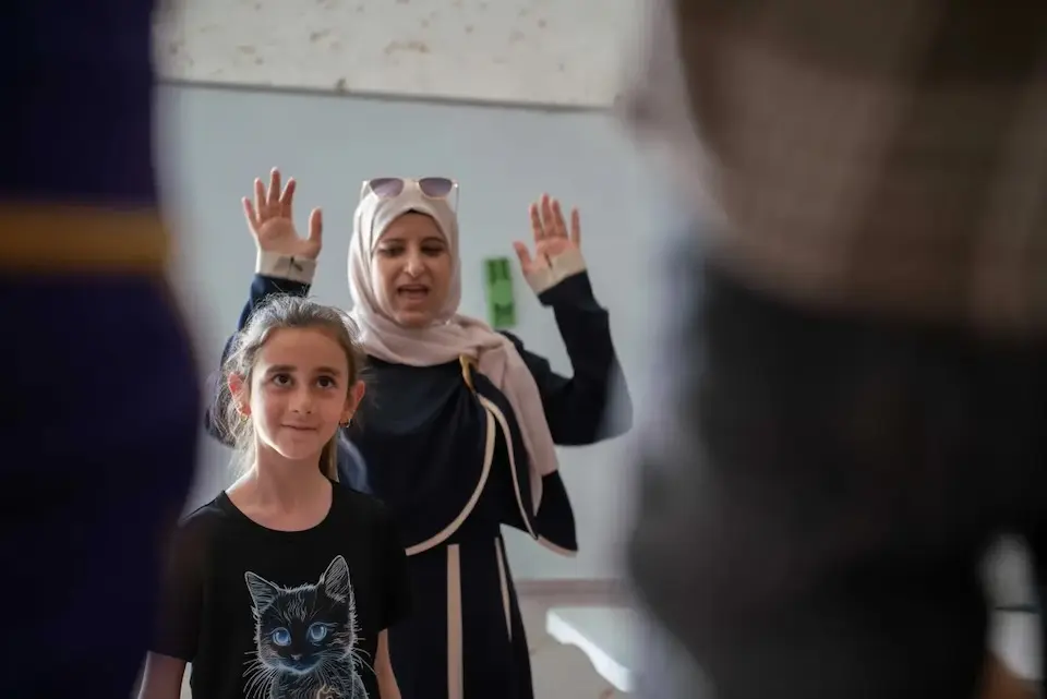 Lina, 9, participates in an exercise that helps children let off steam alleviate psychological distres at a UNICEF-supported program in her village of Qaryut, West Bank.