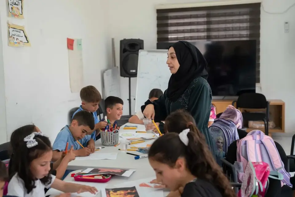 A teacher works with students at a UNICEF-supported psychosocial and educational program in Jaloud village, West Bank.