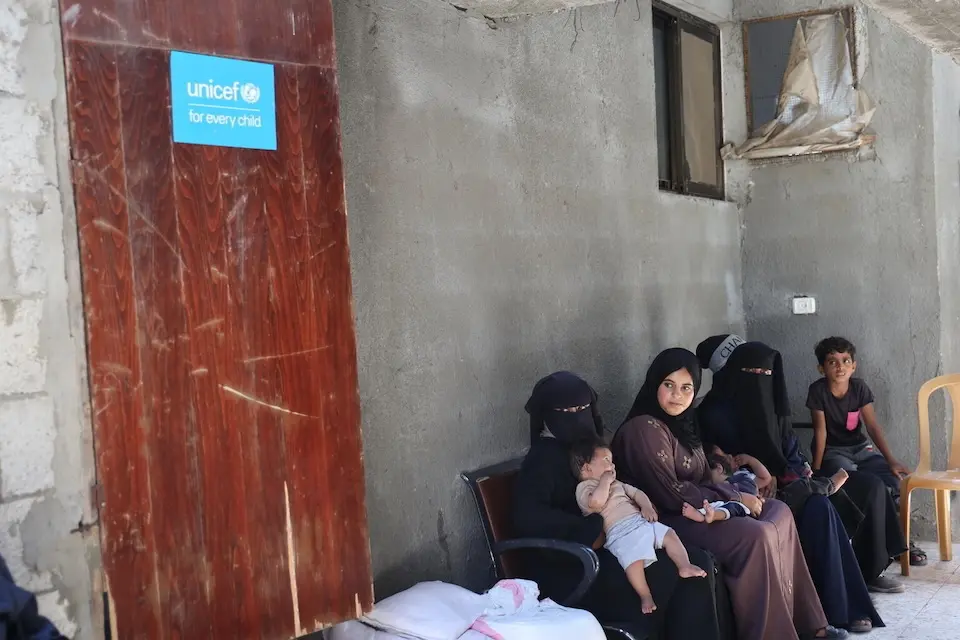 Mothers and children wait outside a UNICEF-supported health center in the Gaza Strip. 