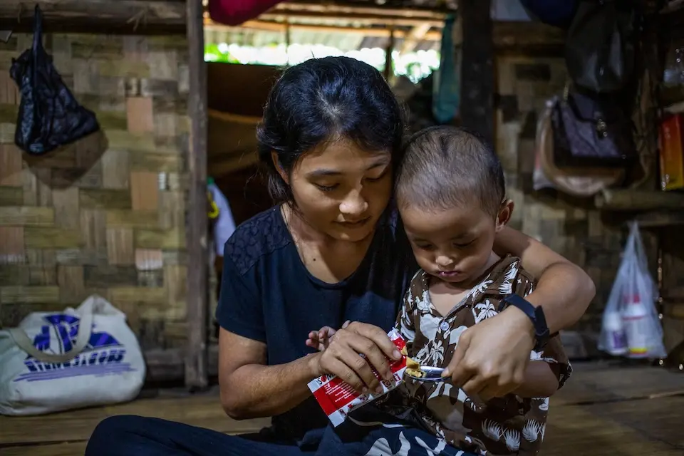 Naw Nal Mu, 20, feeds her child Ready-to-Use Therapeutic Food (RUTF) to support his nutritional recovery at home in Lay Mile Village, Myanmar.  
