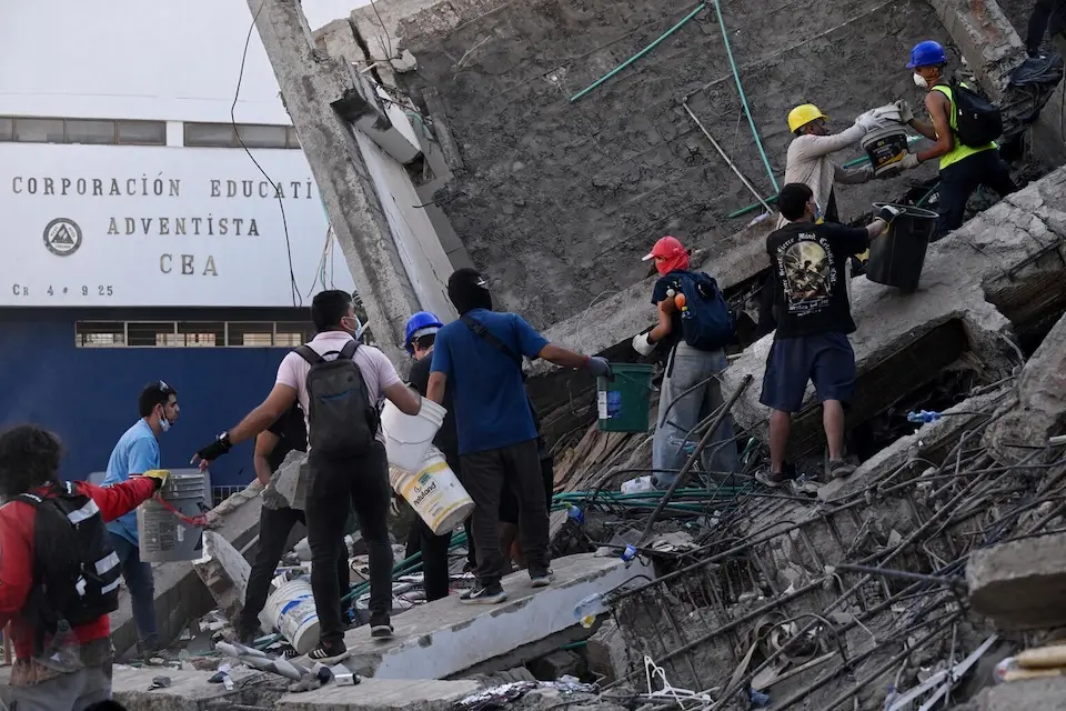 Volunteers and rescuers look for survivors amid the rubble of a collapsed building after an earthquake in Cali, Colombia on Aug. 11, 2026. 