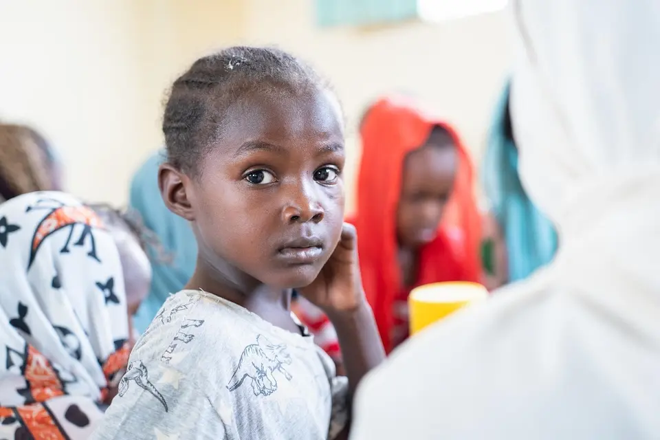 A girl at a UNICEF-sponsored learning center in Sudan looks at the camera.