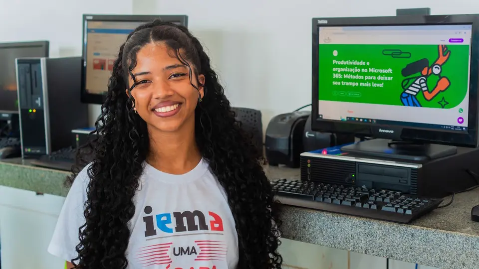 Smiling high school student in front of a computer